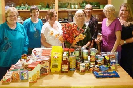 Liz
Salfen and Diane Hultman (third and fourth from left) show the Thanksgiving bounty
collected for families in need.