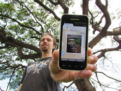 Nate
Ortiz shows his app’s information on the monkeypod tree he’s standing under.