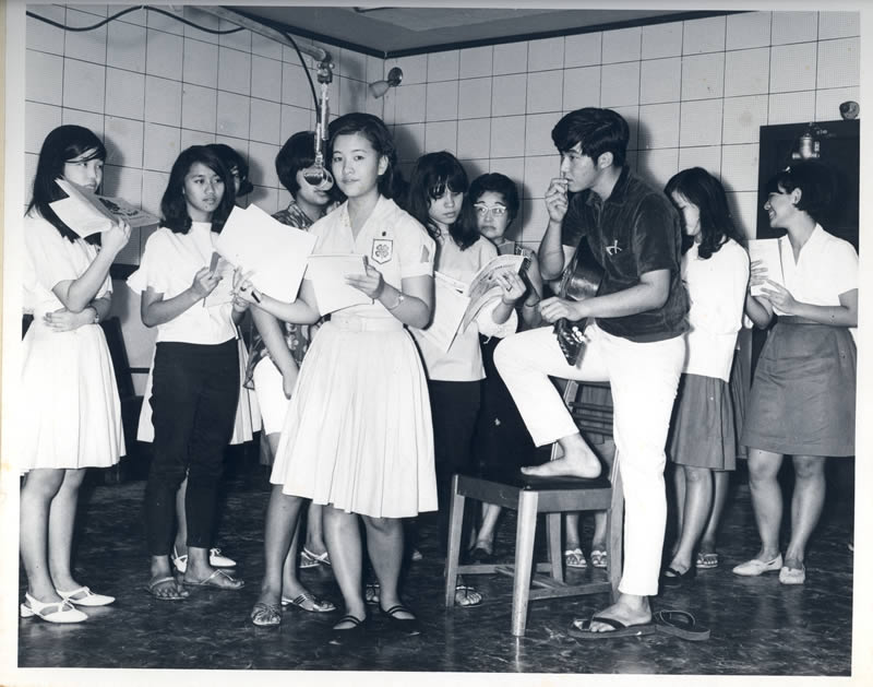 Gathered around a microphone, 4-H youth find their voice. Today’s 4-H programs serve 15,000 Hawai‘i youngsters each year.