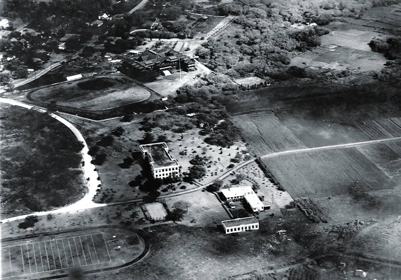 More farm than college: the Manoa campus and its farm as it appeared in 1912. The I-shaped Hawaii Hall and the rectangular engineering building still stand today; the L-shaped building held a chemistry lab. Mid-Pacific Institute is visible in the background.