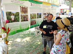 Glenn Teves presenting a colorful array of posters depicting various CTAHR programs on the National Mall in Washington, DC.