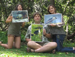 Dr. Lepczyk with students Darcey Iwashita (left) and Alisa Davis (right) holding photos of some friends they’ve made during the course of their work.