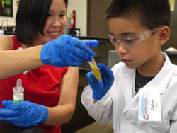 Dylan Tawata (Grade 3) points out the DNA inside the test tube to his mom.