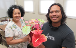 Dr. Teresita Amore and graduate student Peter Toves
hold beautiful and blight-resistant Kaua‘i’ and ‘Maui’ anthuriums.